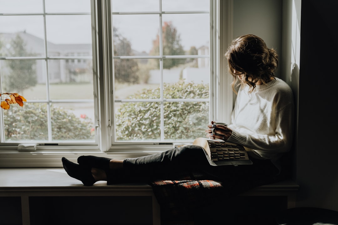 Adult reading quietly by a window in natural light, representing a calm break during a stressful day
